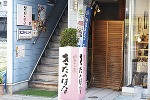 ▲ピンクの看板が目印。階段を登った先が入口です。